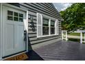 Close up of the gray home's front door and black porch deck and white railing at 5660 Crittenden Ave, Indianapolis, IN 46220
