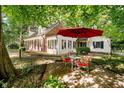 Outdoor patio with a red umbrella, a round table, and seating for four on a brick-paved area at 6280 N Chester Ave, Indianapolis, IN 46220