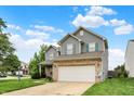 Charming two-story home features blue siding, brick accents, well-manicured lawn, and a two-car garage at 8212 Twin River Dr, Indianapolis, IN 46239