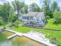 Stunning backyard showcasing a lakefront property with a large deck, patio, and private dock at 9172 W Tulip Dr, Columbus, IN 47201