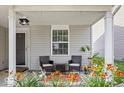 Inviting covered porch with seating area and flower boxes, perfect for relaxing outdoors at 9497 W Stargazer Dr, Pendleton, IN 46064