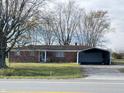 Charming single-story brick home featuring mature trees, and a detached carport on a grassy lot at 9842 N State Road 9, Pendleton, IN 46064