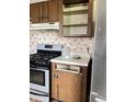 A kitchen featuring a stove and some removed cabinets, with decorative wallpaper at 9842 N State Road 9, Pendleton, IN 46064