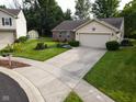 Suburban home with a long driveway and well-kept lawn, showcasing its curb appeal at 9947 Comb Run Ct, Avon, IN 46123