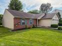 Well-maintained home with brick accents, a green lawn, and neat landscaping in a suburban setting at 9947 Comb Run Ct, Avon, IN 46123