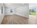 Bright, freshly painted living room featuring new laminate flooring and sliding glass doors to the backyard at 1011 Robin Dr, Anderson, IN 46013