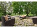 Outdoor patio with comfortable wicker furniture, surrounded by mature trees and lush landscaping at 10198 N State Road 75, North Salem, IN 46165