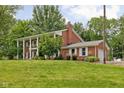Side view of a beautiful brick home featuring white columns, shutters, and a well-maintained lawn at 10198 N State Road 75, North Salem, IN 46165