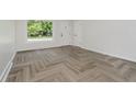 Bright room features luxury vinyl flooring, a large window, and a white painted door at 10434 N Delaware St, Carmel, IN 46280