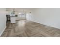 A brightly lit living space flows into a white kitchen and luxury vinyl flooring at 10434 N Delaware St, Carmel, IN 46280