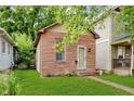 Charming home featuring a red brick facade, green lawn, and a classic design at 1051 Elm St, Indianapolis, IN 46203