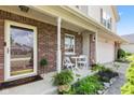 Inviting front porch with brick siding, seating, and decorative plants at 10611 Armstead Ave, Indianapolis, IN 46234