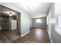 This light-filled living room flows into the kitchen with hard wood flooring and modern neutral paint at 1217 S Ewing St, Indianapolis, IN 46203