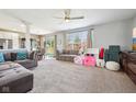 Spacious living room with plush carpeting, gray sofas, and a sliding glass door to the backyard at 12404 Guy Way, Indianapolis, IN 46236