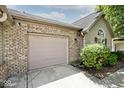 Spacious attached garage featuring brick facade, and a convenient driveway at 1311 Flintlock Dr, Greenwood, IN 46143