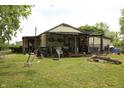 View of backyard with covered porch, assorted items, and ample green space at 1325 N Gavin St, Muncie, IN 47303