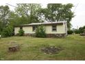 Cozy home with stone accents at the base, set amidst mature trees and a spacious yard at 1325 N Gavin St, Muncie, IN 47303
