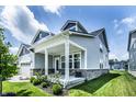 Side angle of the home featuring a cozy covered side porch with brickwork, and a well maintained lawn at 14404 Stairbridge Pl, Carmel, IN 46074