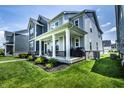 Stylish home featuring a covered porch, manicured landscaping, and a modern design at 14404 Stairbridge Pl, Carmel, IN 46074