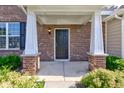 Welcoming front porch with brick pillars, a dark front door, and green bushes creating curb appeal at 14620 Hinton Dr, Fishers, IN 46037