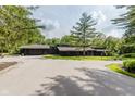 Expansive front exterior with a large driveway and surrounding mature trees at 1616 W 116Th St, Carmel, IN 46032