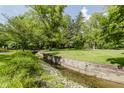 Scenic view of the yard with a creek and lush landscaping at 1616 W 116Th St, Carmel, IN 46032
