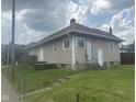 Back of a tan house with a small deck and multiple entrances. Lots of green lawn in view at 1902 Westview Dr, Indianapolis, IN 46221