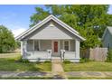 Attractive home featuring a red front door, brick accents, and a cozy porch area at 1927 N Cherry St, Columbus, IN 47201