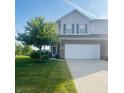 Well-manicured two-story home featuring a two-car garage, established tree and green lawn at 2485 Blue Ridge Dr, Greenwood, IN 46143