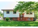 Split-level home with white siding, orange trim and a small front porch with a 'For Sale' sign at 2606 Shakespeare Dr, Southport, IN 46227