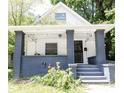 Charming bungalow featuring a covered front porch with gray brick supports and updated string lighting at 2650 S Meridian St, Indianapolis, IN 46225