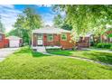 Charming brick bungalow with covered porch, landscaped yard, and sidewalk at 319 S Webster Ave, Indianapolis, IN 46219