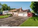 View of the home showing the front, driveway, garage and lawn, with a red accent fence at 4020 Eisenhower Dr, Indianapolis, IN 46254