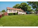 Landscaped front yard and charming split-level home with red roof and attached garage at 4020 Eisenhower Dr, Indianapolis, IN 46254