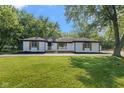 Charming ranch-style home with freshly painted white brick, black trim, and lovely, landscaped yard at 4305 Five Points Rd, Indianapolis, IN 46239