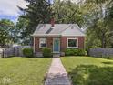 Charming brick home with a colorful front door and a well-maintained lawn at 4523 Kingsley Dr, Indianapolis, IN 46205