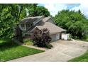 View of the home's landscaped yard, attached garage and long driveway at 4976 Rockne Cir, Carmel, IN 46033