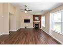 Bright living room featuring wood floors, a fireplace, ceiling fan, and lots of natural light at 5642 Southern Mist Dr, Indianapolis, IN 46237