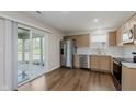 Modern kitchen with stainless steel appliances, light wood cabinets, and hardwood floors at 5672 High Timber Ln, Indianapolis, IN 46235