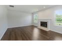 Bright living room featuring a fireplace, hardwood floors, and natural light at 5672 High Timber Ln, Indianapolis, IN 46235