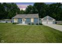 Charming blue home with a well-maintained lawn and a detached two-car garage at 5902 Oak Ln, Anderson, IN 46013