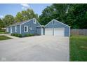 Spacious concrete driveway leads to a detached two-car garage, connecting to the home's rear entrance at 5902 Oak Ln, Anderson, IN 46013