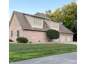 Spacious three-car garage featuring a brick exterior and well-maintained landscaping with mature trees at 5993 E County Road 100 S, Avon, IN 46123