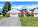 Exterior view of a single-story home with an attached garage and a neatly maintained front lawn at 6402 Friendship Cir, Indianapolis, IN 46268