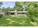 Charming single-story home featuring well-maintained landscaping, a chimney and a yellow front door at 6430 N Rural St, Indianapolis, IN 46220