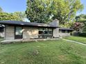 Low angle of single-story home with large windows, stone and mulch flower beds at 6430 N Rural St, Indianapolis, IN 46220