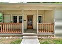 Inviting front porch with wooden railing, decorative pillars and a wood door at 696 W Mill St, Danville, IN 46122