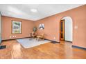 Sunlit living room with hardwood floors, stylish seating, and an arched doorway at 696 W Mill St, Danville, IN 46122