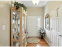 Inviting entryway featuring hardwood floors and decoratively arranged display cabinet at 712 Disciples Way, Greenwood, IN 46143
