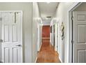 Long hallway with wood floors, featuring several doorways and decorative wall art at 712 Disciples Way, Greenwood, IN 46143